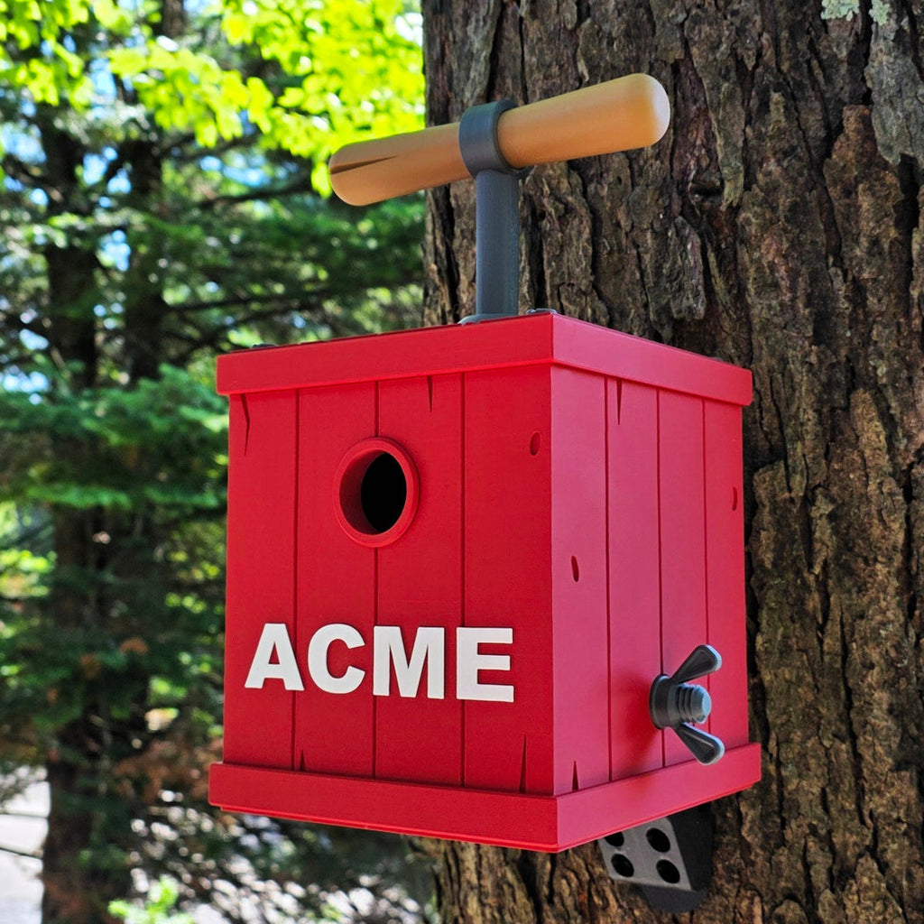 Red birdhouse with 'ACME' branding attached to a tree