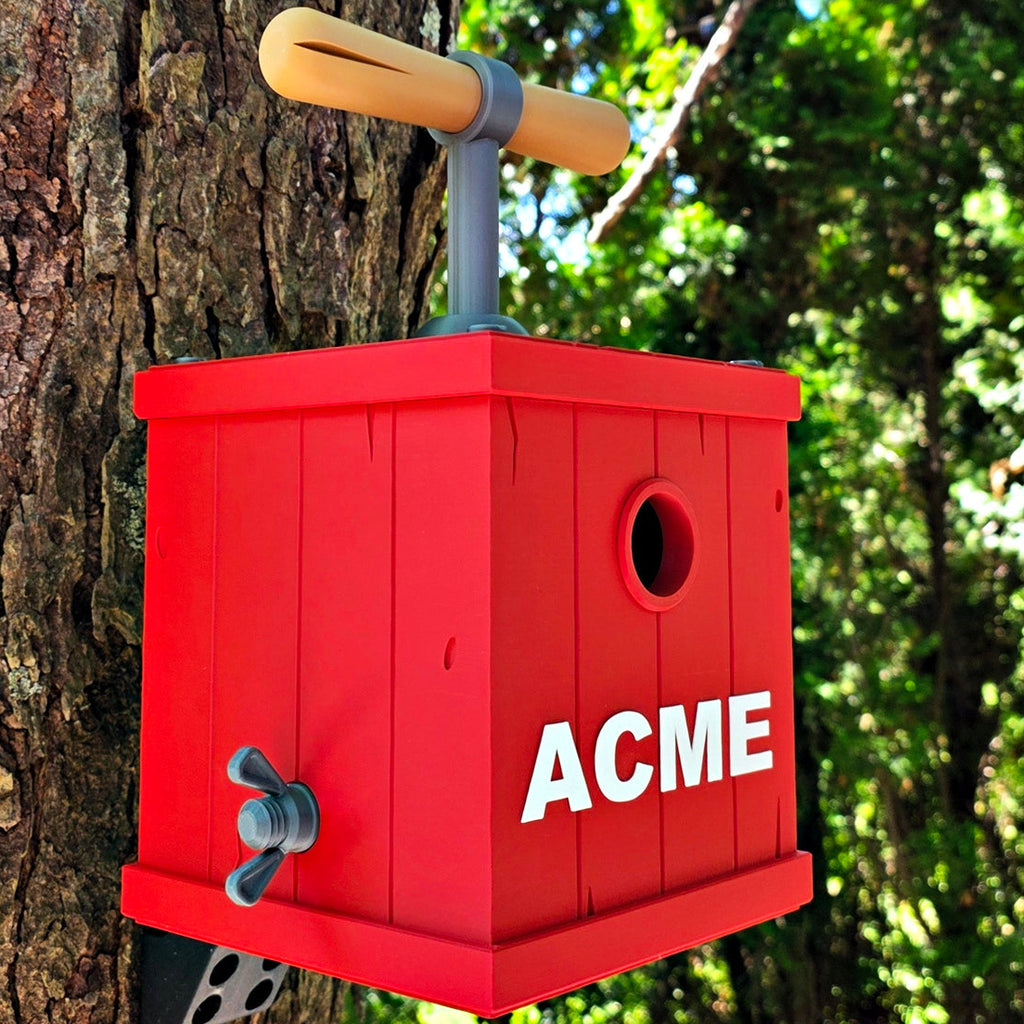 Red birdhouse with 'ACME' branding attached to a tree