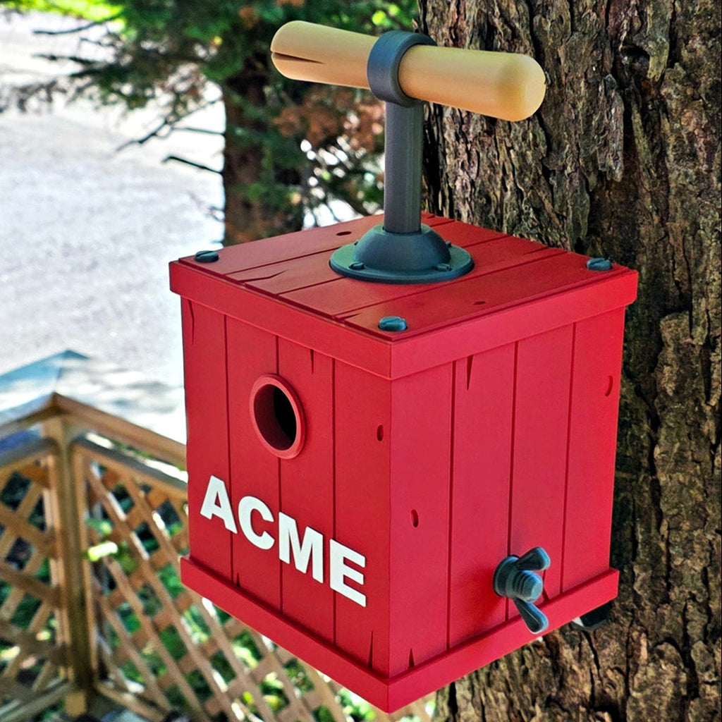 Red birdhouse with 'ACME' branding attached to a tree