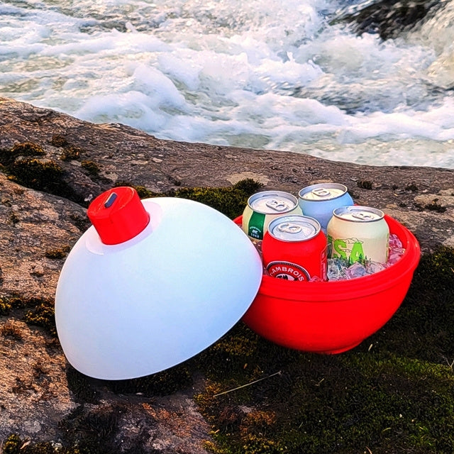 Red and white coolers with drinks by a flowing river
