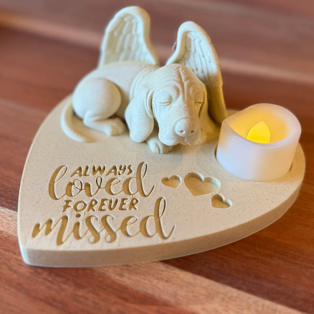Memorial ornament with Basset Hound with Angel Wings figurine and a candle on a wooden surface