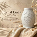 Urn with Bernese Mountain Dog design in the 'Eternal Lines Collection' on a textured surface with dried plants.