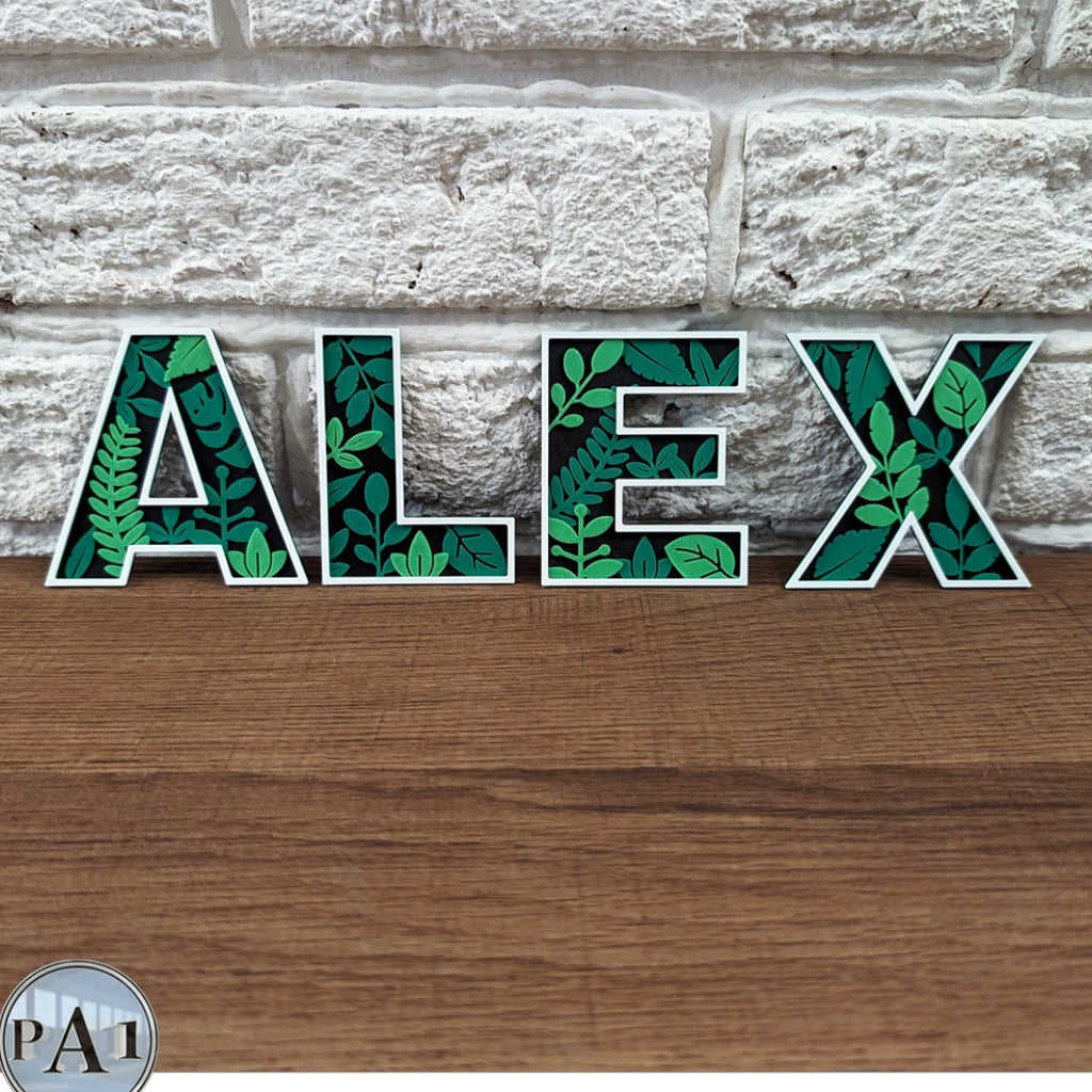 Decorative letters spelling 'ALEX' with leaf pattern on a stone and wood background