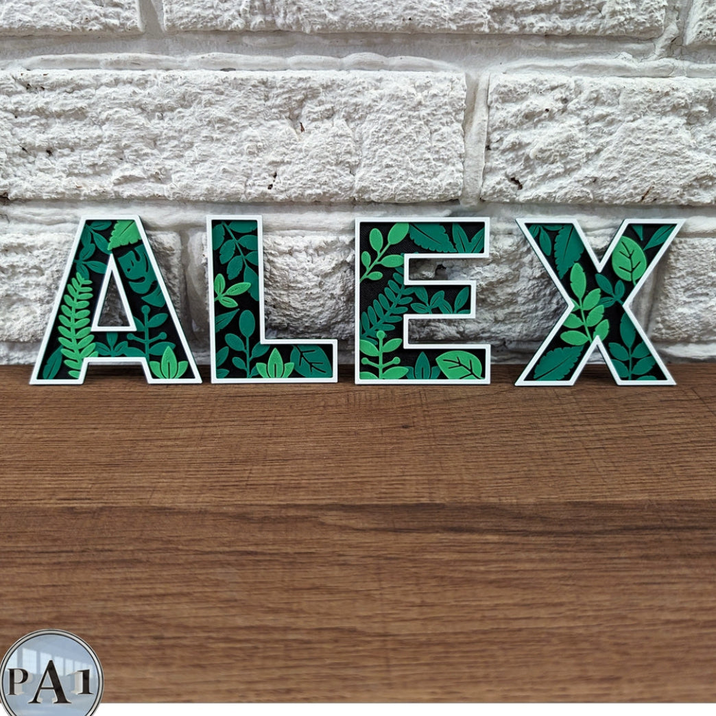 Decorative letters spelling 'ALEX' with leaf pattern on a stone and wood background