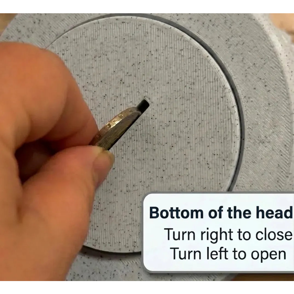 Hand using a tool to interact with a circular metallic object, with text instructions on the screen.