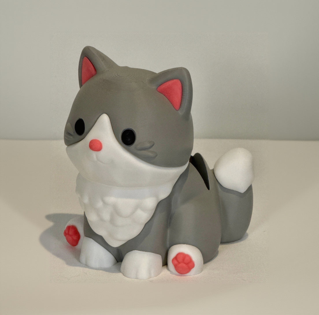 Gray cat-shaped figurine with red accents on a light background