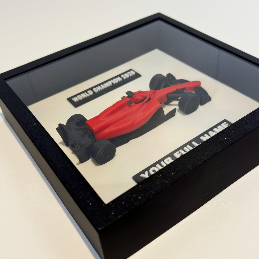 Red Formula 1 car model in a black frame with customizable text