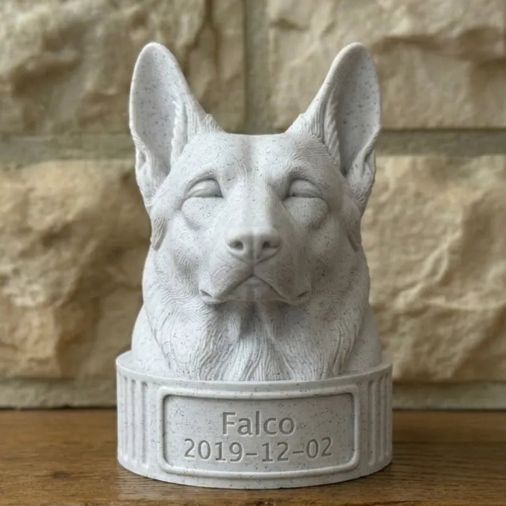 White stone sculpture of a German shepherd dog's head with 'Falco' and a date on a wooden surface.