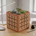 Decorative planter with succulents on a desk next to a lamp and pen