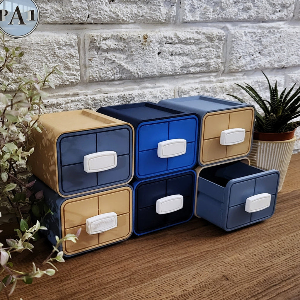 Set of blue and beige storage drawers on a wooden surface with a stone wall background.