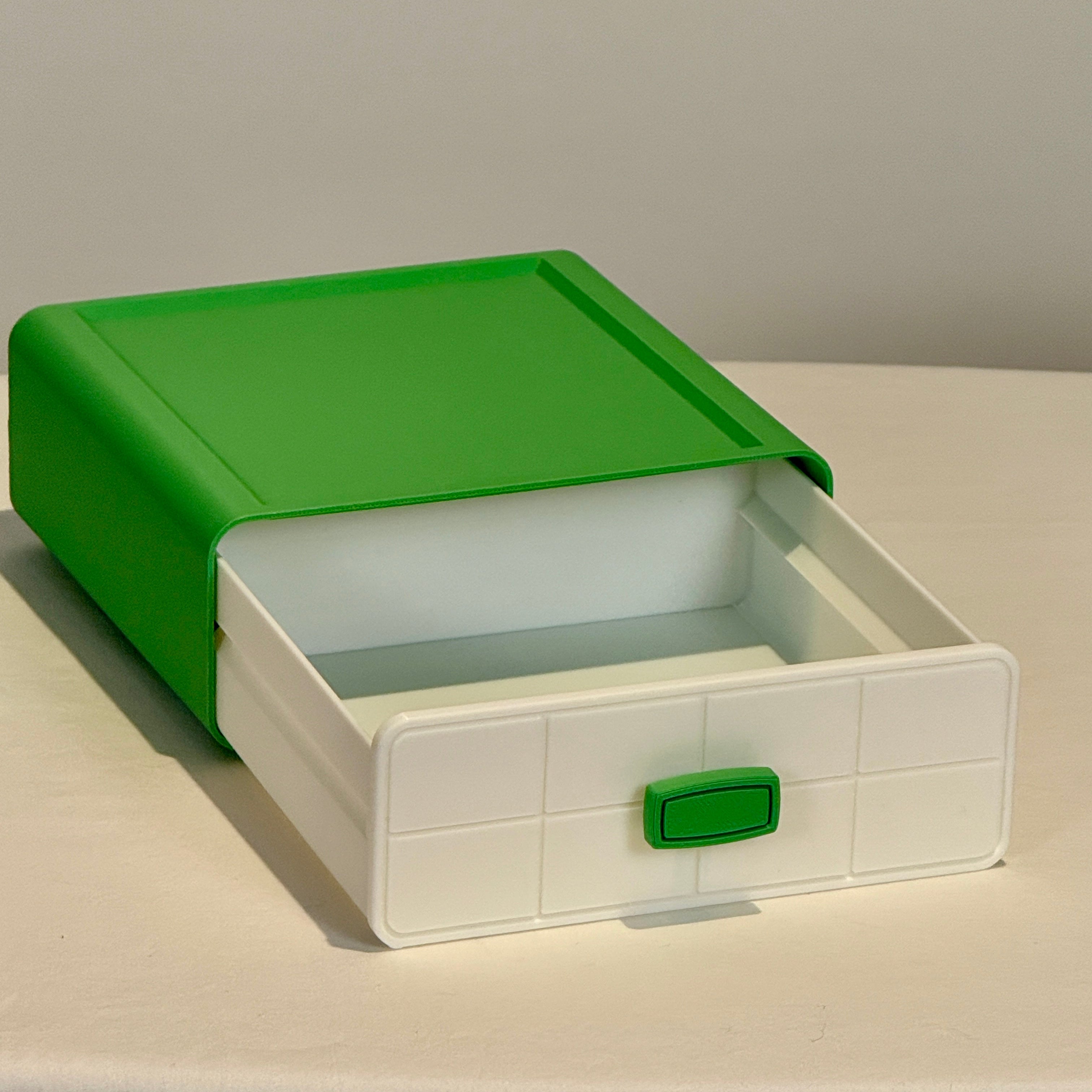 Green and white storage box with a lid on a light surface