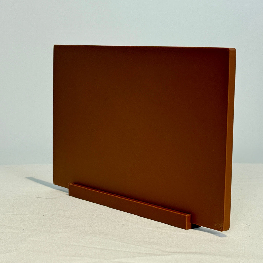 Brown rectangular object on a white surface with a light gray background