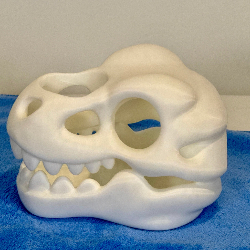 White plastic skull on a blue towel with a white background
