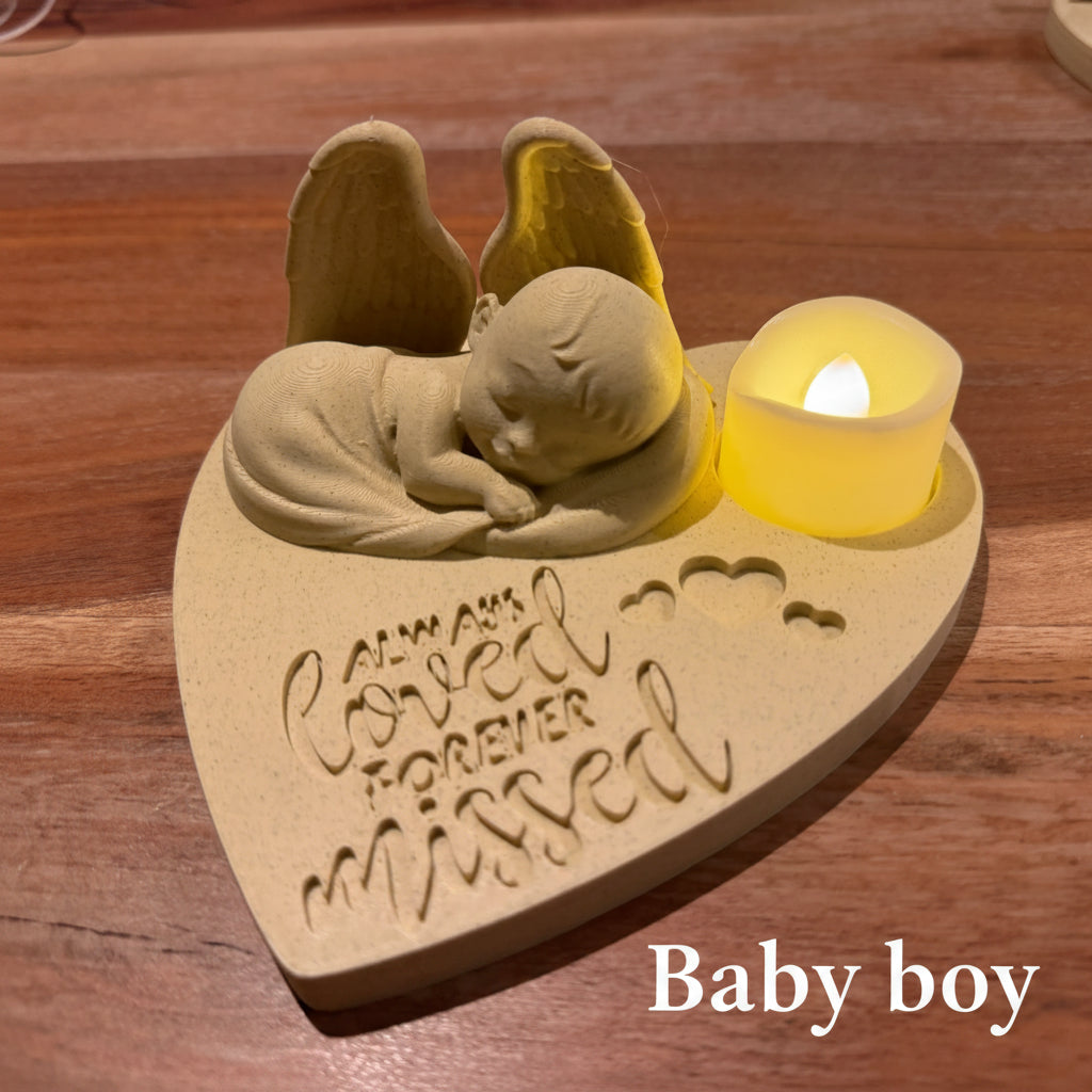 Memorial ornament with baby boy As an angel and heart-shaped base on a marble, surface