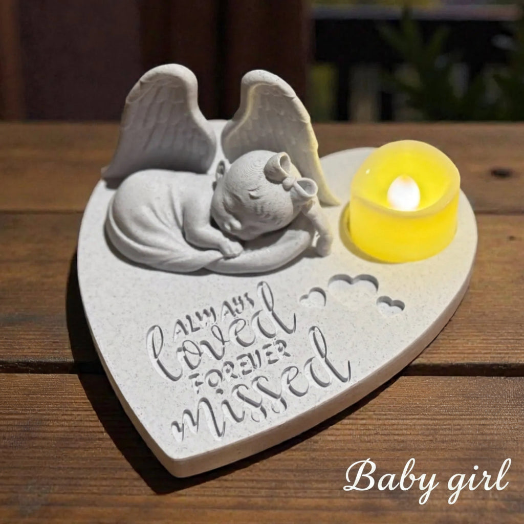 Memorial ornament with baby girl as an Angel on a heart-shaped base with a candle, set against a marble background.