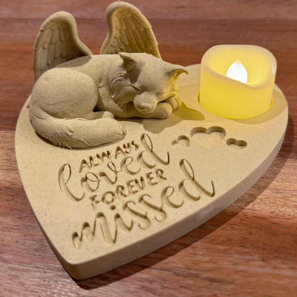 Memorial plaque featuring a border collie with Angel wings and a candle on a wooden surface