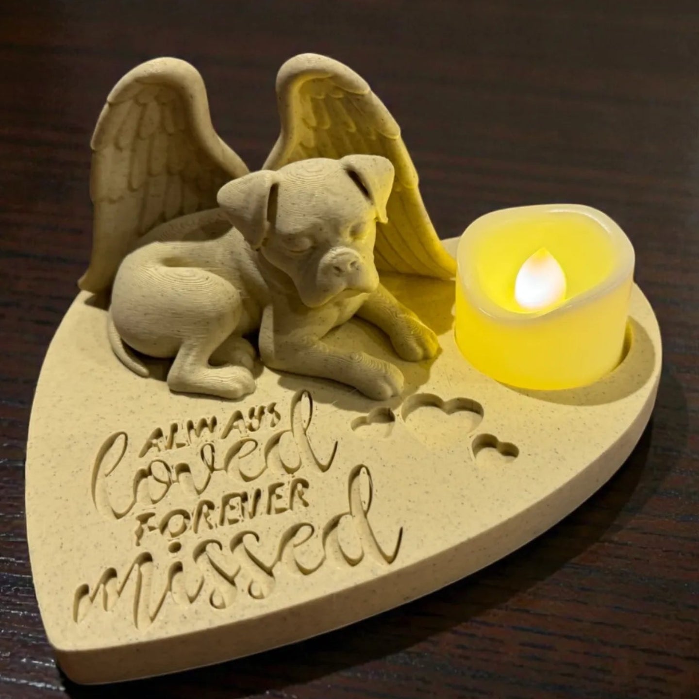Memorial ornament featuring a boxer with Angel wings and a candle on a wooden surface