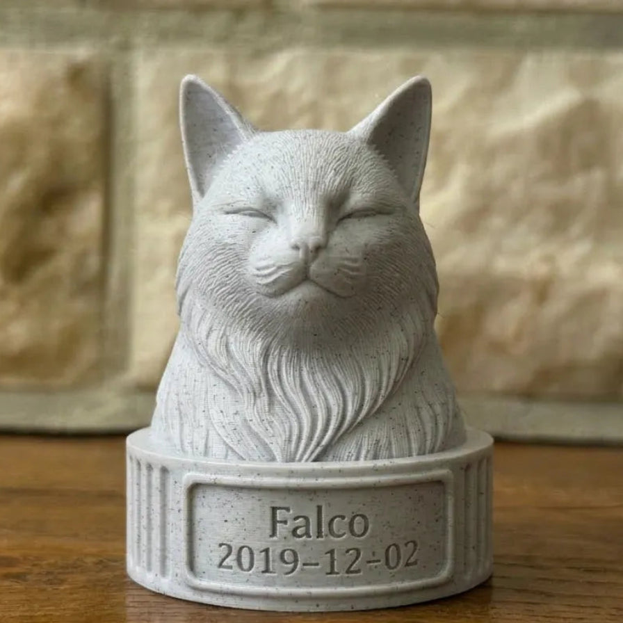 Cat-shaped stone sculpture with 'Falco' and a date on a wooden surface.