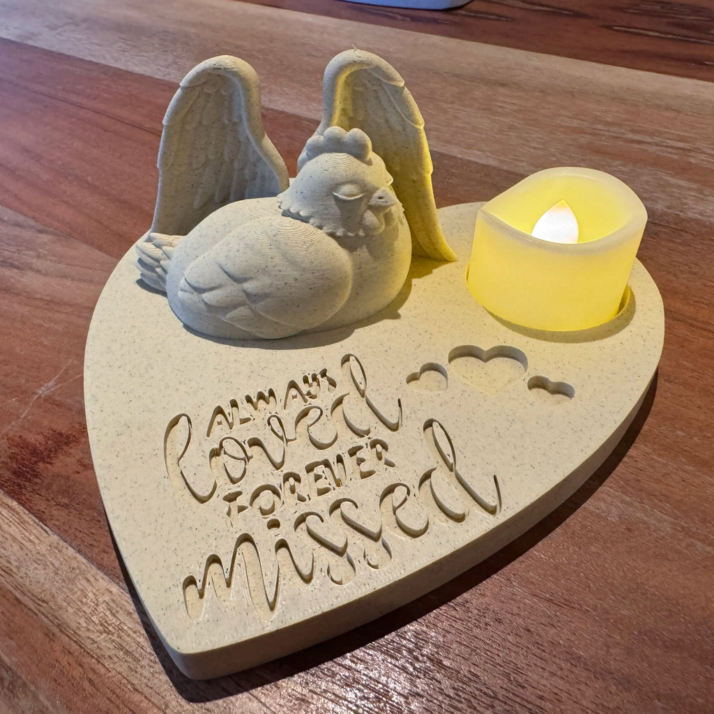 Memorial ornament with angel wings and a candle on a wooden surface