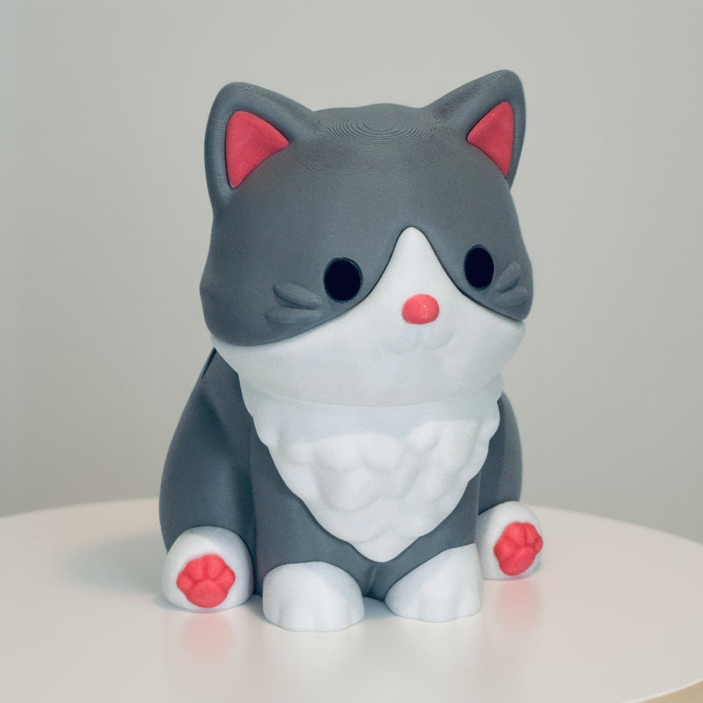 Gray cat-shaped figurine with pink accents on a white background