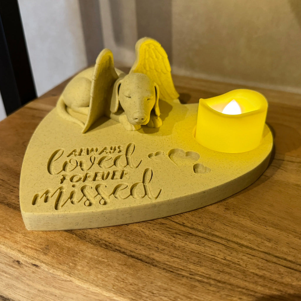 Heart-shaped wooden plaque with a dachshund design and a small candle on a wooden surface.