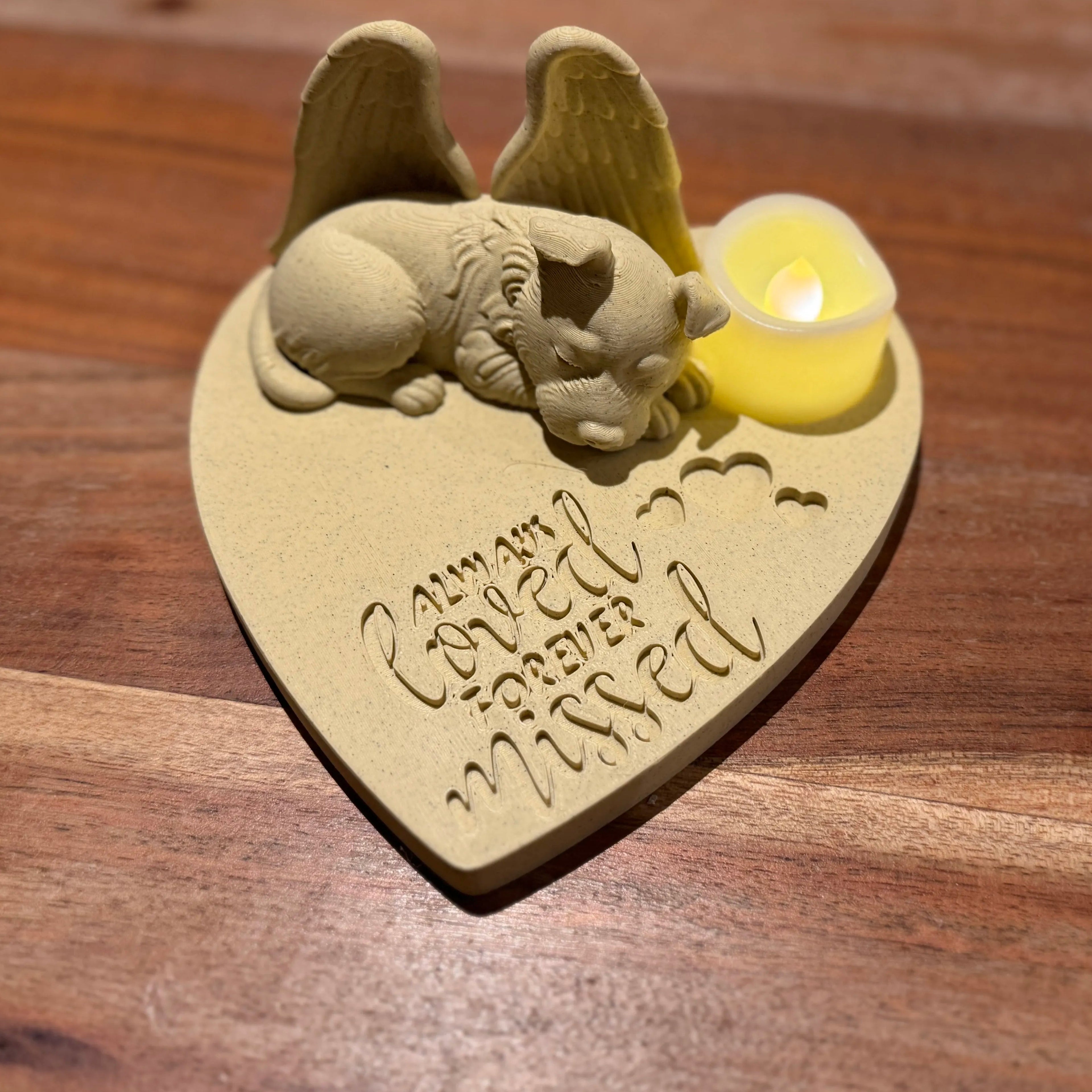 Heart-shaped decorative piece with a fox terrier with Angel wings and a candle on a wooden surface