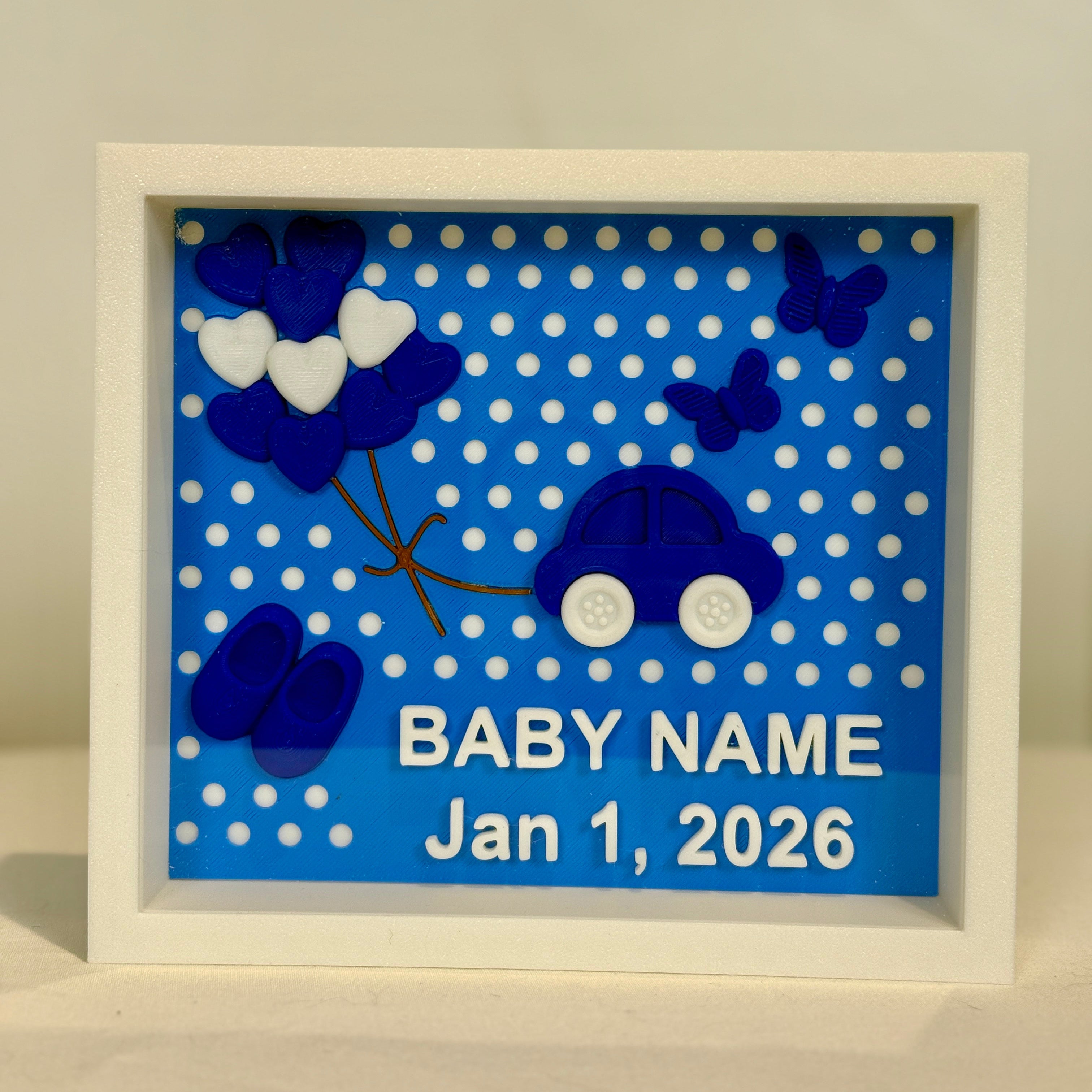 Framed baby gift with blue car, white hearts, and polka dots on a blue background.