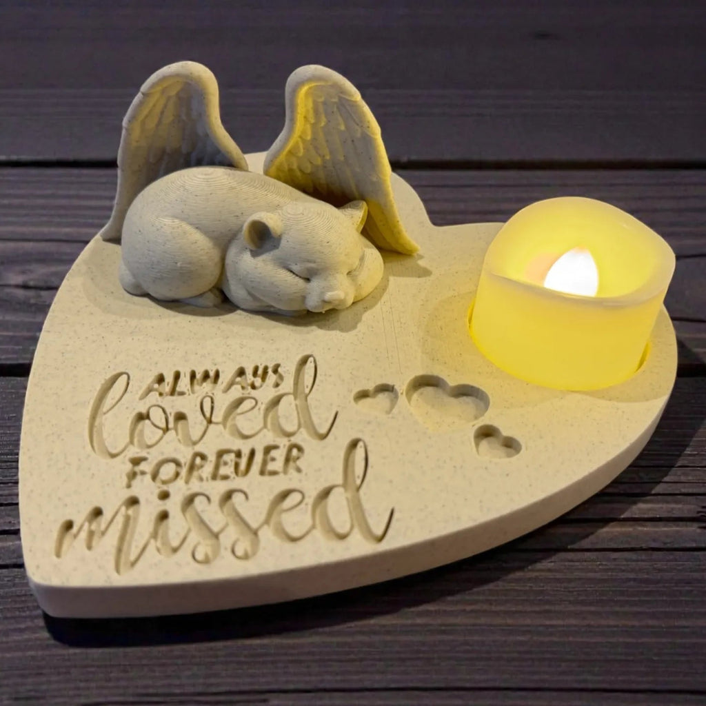Memorial sculpture of a sleeping hamster with Angel wings and a candle on a wooden base with 'Always Loved Forever Missed' text.