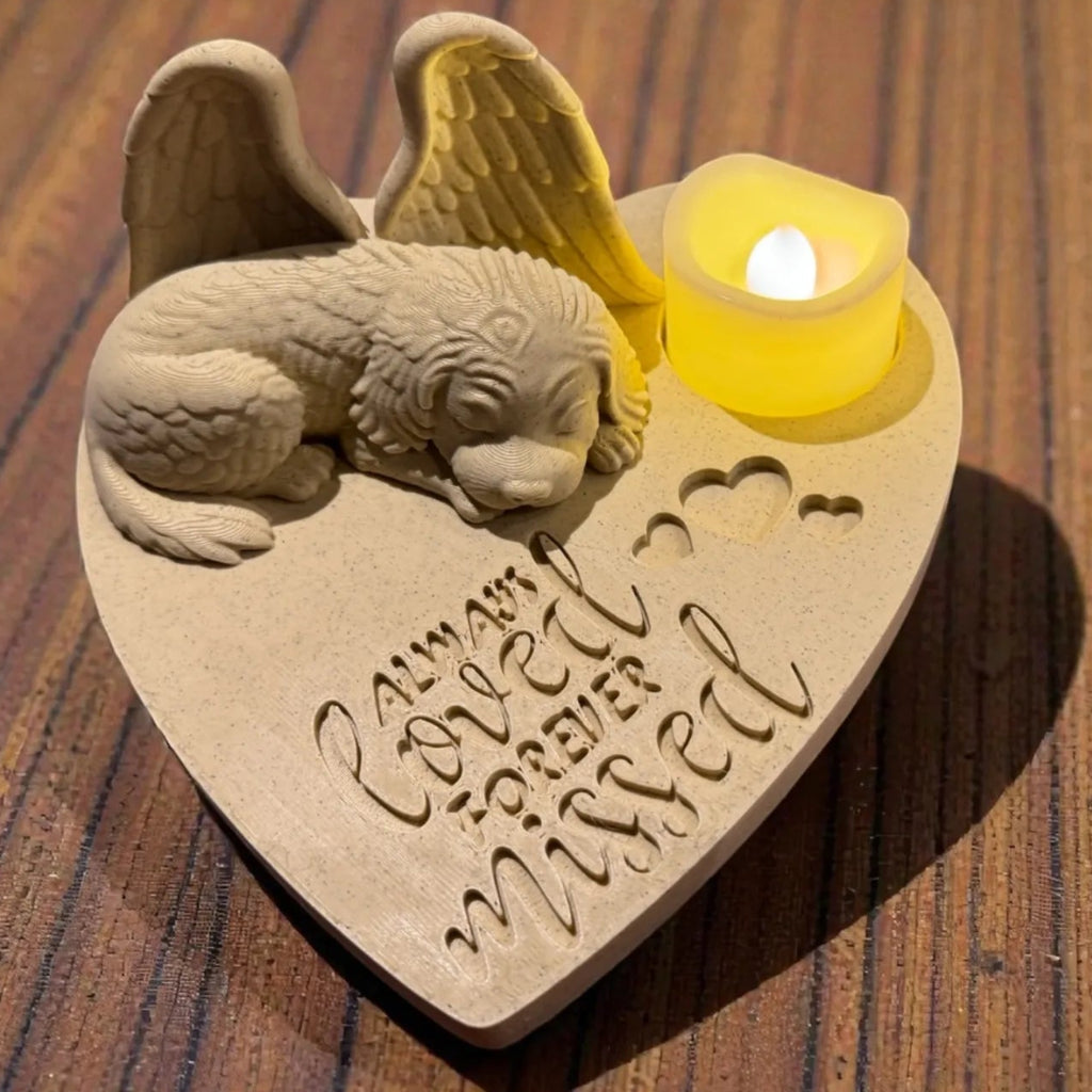 Heart-shaped memorial with a labradoodle with Angel wings and candle on a wooden surface