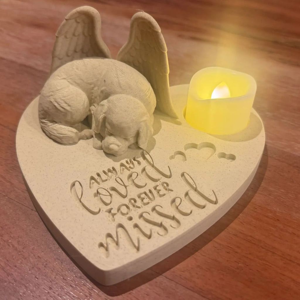 Memorial plaque with a Newfoundlander wearing angel wings and a candle on a wooden surface