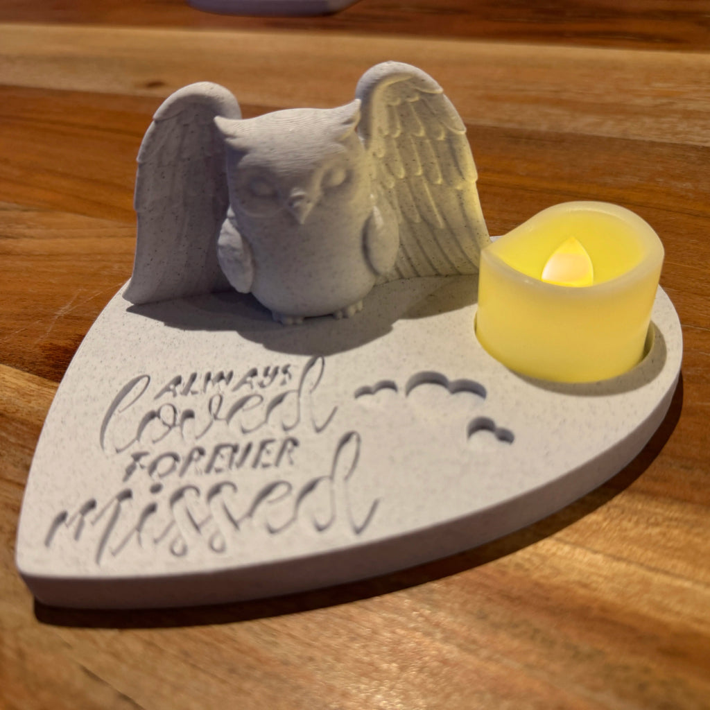 Memorial ornament featuring an owl wearing Angel wings and candle on a wooden surface