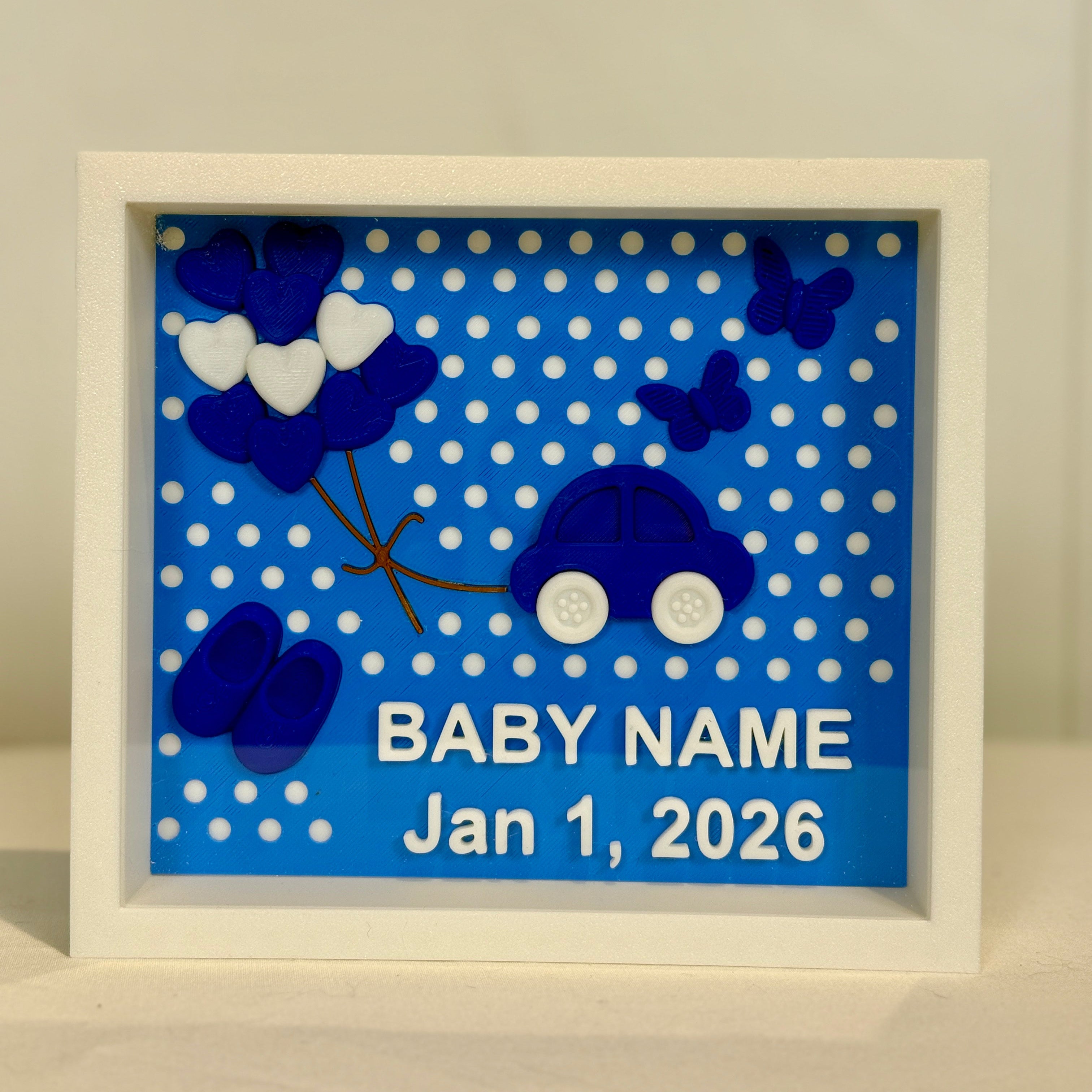 Decorative baby frame with blue polka dots, blue car, and white hearts on a light gray background.