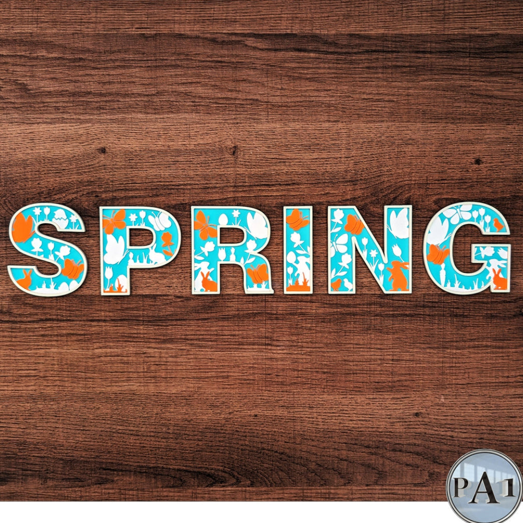 Wooden background with 'SPRING' text in colorful letters, PAT logo in corner.